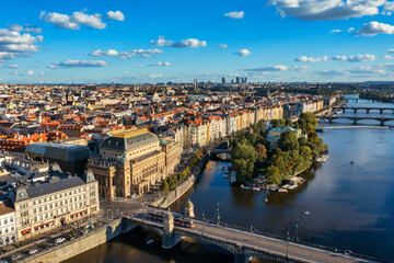 National Theatre located in Prague, Czech Republic on the Vltava River. Legion bridge on river Vltava. National Theatre (Narodni Divadlo) on embankment in sunbeams of evening sunset sunlight. Prague