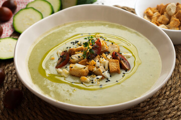 Vegetable cream with zucchini and potato. Typical Spanish tapa recipe decorated with croutons, hard-boiled egg and black sesame.
