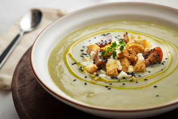 Vegetable cream with zucchini and potato. Typical Spanish tapa recipe decorated with croutons, hard-boiled egg and black sesame.