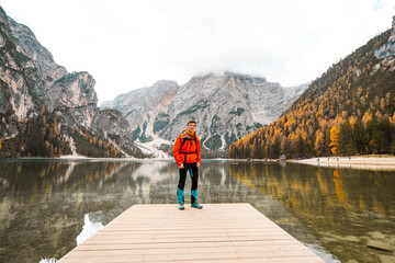 Fototapeta na wymiar person on the pier with mountains and lake in background in dolomites