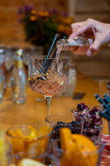 the glass of gin tonic. pouring tonic