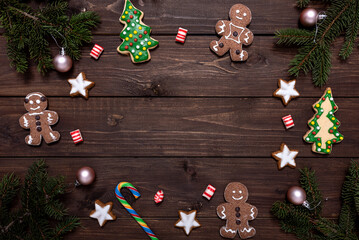 Christmas cookies and fir branches on wooden background