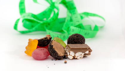 various sweets and tape measure isolated on white background