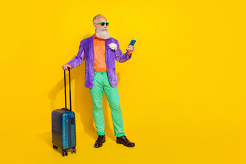 Full body portrait of handsome dandy aged man hold use telephone empty space isolated on yellow color background