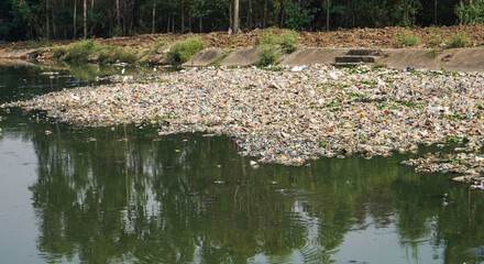 Pollution control day, plastic and garbage polluted river, waste materials floating on river water and polluted the water making it toxic, Pollution concept