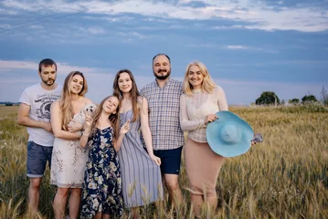 Fotobehang The whole family met in the village for a beautiful family photo on the field at sunset for the album. Escorting the family in the evening at sunset © magda91fotolia