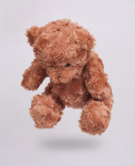 Teddy bear levitating on white background with shadow