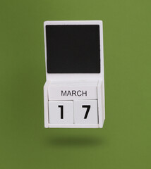 Wooden calendar with March 17 date levitating on green background. St.Patrick 's Day