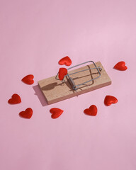 Mousetrap with hearts on a pink background. Love concept, valentine's day, love scam