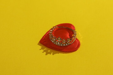 Golden crown or ring and heart on a yellow background. Valentine's day, love concept