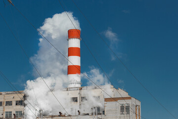 Obraz premium The pipe of the industrial plant emits toxic smoke into the atmosphere and air. Pollution of the environment and ecology. Thermal power plant