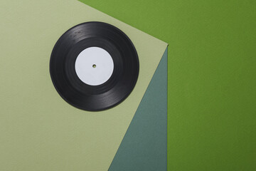 Vinyl record on a paper cube. Optical illusion. Geometric composition. Minimalistic creative layout