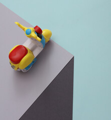 Toy moped on a paper cube. Optical illusion. Geometric composition. Minimalistic creative layout