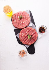 Raw fresh hamburger patties or cutlet ready to cook on white textured background.  Top view. Place for text. - 550666709