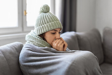 Heating Problems. Closeup Shot Of Young Woman Freezing At Home