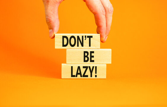 Motivational and do not be lazy symbol. Concept words Do not be lazy on wooden blocks on a beautiful orange table orange background. Businessman hand. Business do not be lazy concept. Copy space.