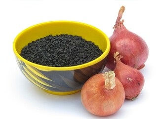 Onion seeds in a bowl on white background 