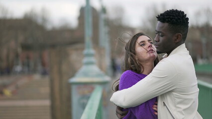 Young interracial couple embrace together. Boyfriend hugging girlfriend