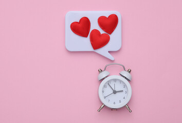 Speech bubble with hearts and alarm clock on a pink background. Valentine's Day
