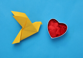 Origami dove with heart box on blue background. Valentine's day concept
