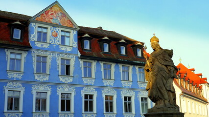 Haus mit malerischer blauen Fassade in Altstadt von Bamberg  neben Statue von Königin Kunigunde