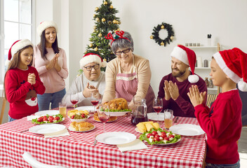 Merry Christmas. Happy family in three generations has dinner with the family, serving the main hot dish. Celebrating unity at the dinner table.