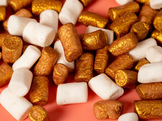 Mini marshmallows on a pink background. Marshmallow gold and white.