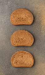 Three pieces of tasty rye wnd wheat bread on grey background,  top view