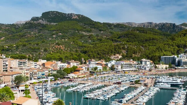Aerial view of SOLLER, town in the island of MAJORCA (MALLORCA in Spanish),with the movement of the clouds,the people and the traffic of the boats in its port.Time Lapse.Camera movement: Panning Right
