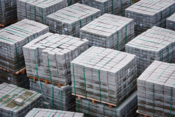 Paving slabs, tiles piled in pallets. Warehouse paving slabs. Pile of new paving slabs on wooden...