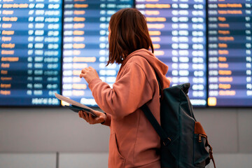 Young woman is waiting for the boarding on the plane at the airport.