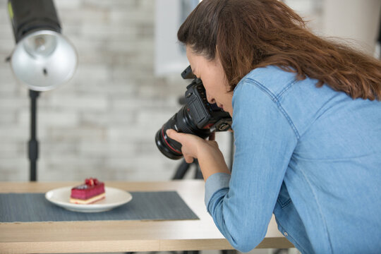 woman blogger is taking a picture of a cake