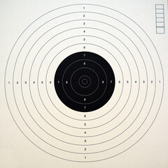 Paper target for a firearm. The target has a circular shape and a black center.