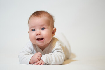 portrait of an infant lying on his back against a white background