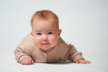 Portrait of an infant learning to crawl on a white background