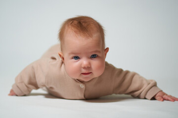 Portrait of an infant learning to crawl on a white background