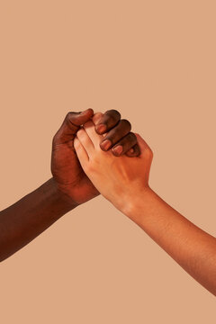 Unrecognizable multiracial couple holding hands