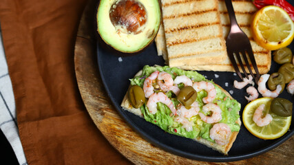 Guacamole toast with avocado, shrimp and olives. Healthy snack. Keto.