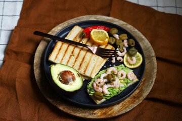 Guacamole toast with avocado, shrimp and olives. Healthy snack. Keto.