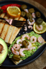 Guacamole toast with avocado, shrimp and olives. Healthy snack. Keto.
