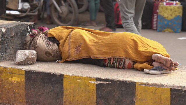 A poor woman sleeping on road