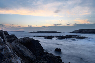 Water of the beach surrounded by black rocks