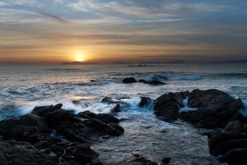 Sunset over the beach with large rocks