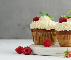 Baked cupcakes with white butter cream on the table, delicious dessert