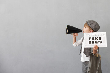 Newsboy shouting against grunge wall background. Boy selling fake news