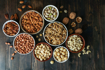 Nuts variety in the bowls - cashew, hazelnut, macadamia, pistachio, almond, walnut, peanut, pecan