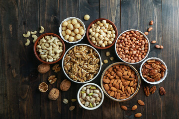 Obraz na płótnie Canvas Nuts variety in the bowls - cashew, hazelnut, macadamia, pistachio, almond, walnut, peanut, pecan