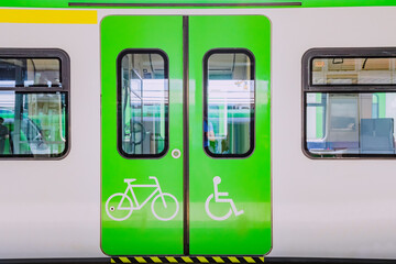 A carriage of a modern electric train for transporting passengers with wheelchair and bicycle symbols. Accessibility concept