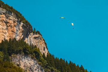 Beautiful alpine summer view with paragliders at the famous Seealpsee lake, Appenzell, Alpstein, Switzerland