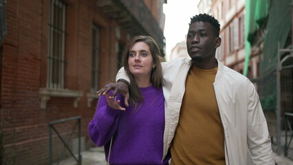 Young interracial couple walking together in street. African boyfriend arm around girlfriend3